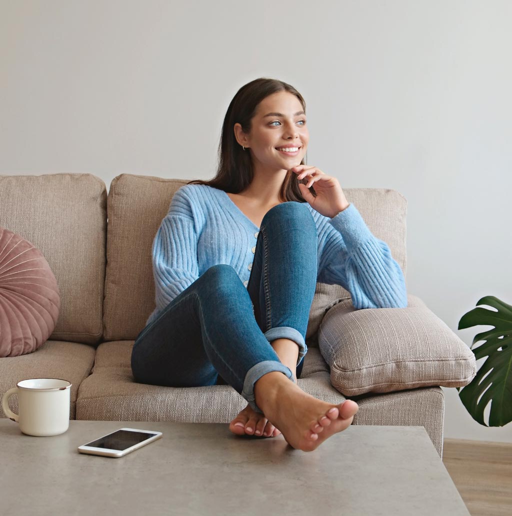 Woman relaxing on couch with feet up